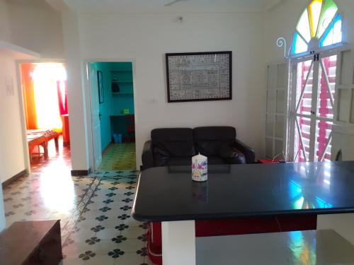 a living room with a table and a couch at Holi-Wood Guesthouse in Puducherry