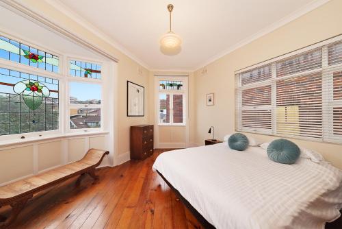 una camera con un letto e due finestre di Coastal Penthouse at Coogee Beach a Sydney