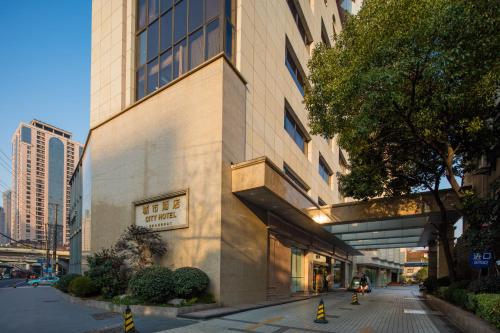 a building with a sign on the side of it at City Hotel Shanghai in Shanghai