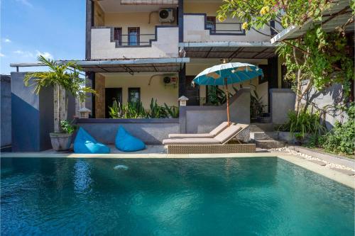 a house with a swimming pool with an umbrella at Terrace Garden Homestay and Spa in Jimbaran