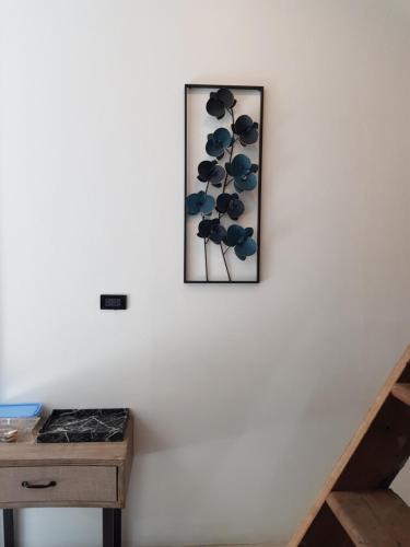 a picture of a plant on a wall next to a table at Tepbunthom Hostel in Bangkok