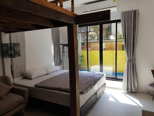 a bedroom with a canopy bed and a large window at Tepbunthom Hostel in Bangkok