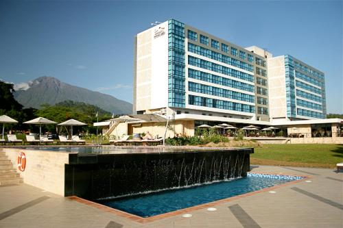 a hotel with a fountain in front of a building at Mount Meru Hotel in Arusha