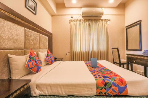 een hotelkamer met een bed, een bureau en een computer bij FabHotel Frazer Suites Pulikeshi Nagar in Bangalore