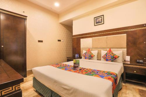een hotelkamer met een bed en een televisie bij FabHotel Frazer Suites Pulikeshi Nagar in Bangalore