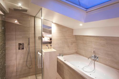 a bathroom with a shower, sink, and tub at Georgette Hôtel & Restaurant in Paris