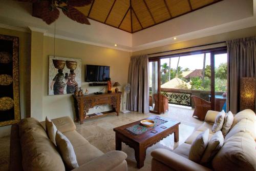 a living room with a couch and a table at Bayshore Residence in Candidasa