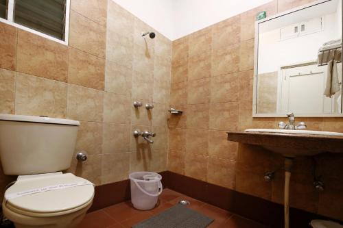 ein Badezimmer mit einem WC, einem Waschbecken und einem Spiegel in der Unterkunft Hotel Yatrik in Allahabad