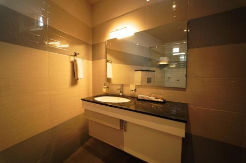 a bathroom with a sink and a mirror at WithInn Hotel - Kannur Airport in Kannur