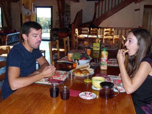 a man and a woman sitting at a table eating food at Chambres d hotes AZKENA in Arrast-Larrebieu
