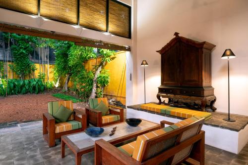 a living room with a couch and chairs and a fireplace at De Saram House by Geoffrey Bawa in Colombo
