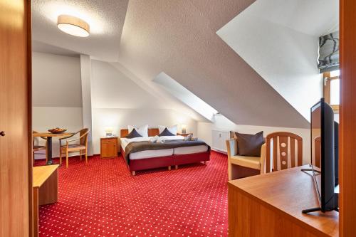 a hotel room with a bed and a desk at Landhotel Donaublick in Obernzell