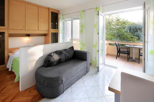a living room with a chair and a bedroom at Resort Trcol in Novalja
