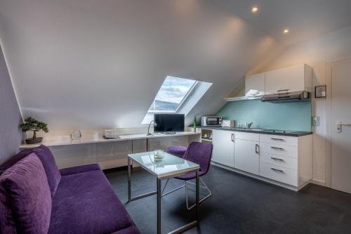 a living room with purple chairs and a table at Hotel Stadt Heidelberg in Darmstadt