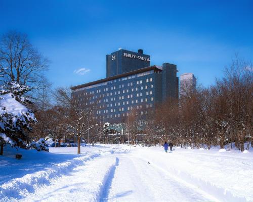 a snow covered street in front of a building at Sapporo Park Hotel in Sapporo