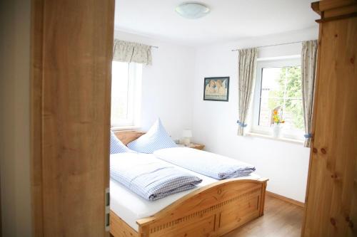 Schlafzimmer mit einem Bett mit weißer Bettwäsche und einem Fenster in der Unterkunft Ferienhof Settele in Bad Wörishofen