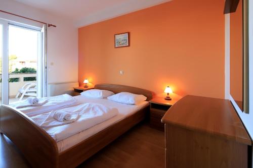 a bedroom with a bed with two night stands and two lamps at Resort Trcol in Novalja