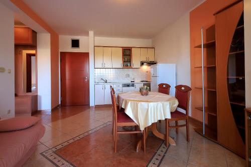 a kitchen and dining room with a table and chairs at Resort Trcol in Novalja