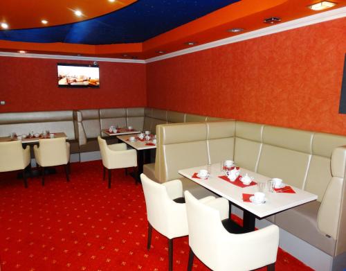 comedor con mesas y sillas y TV en Budai Panzió, en Székesfehérvár