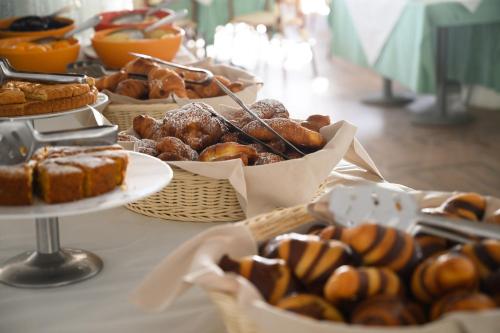 a table topped with baskets of pastries and other foods at Residence Le Acacie in Capoliveri
