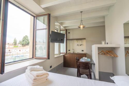 a kitchen with a table and a large window at CABANON urban apartments in Peschiera del Garda