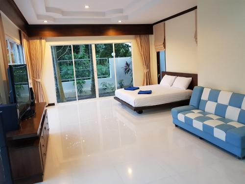 een slaapkamer met een bed, een bank en een televisie bij ViewPoint Villa in Kathu