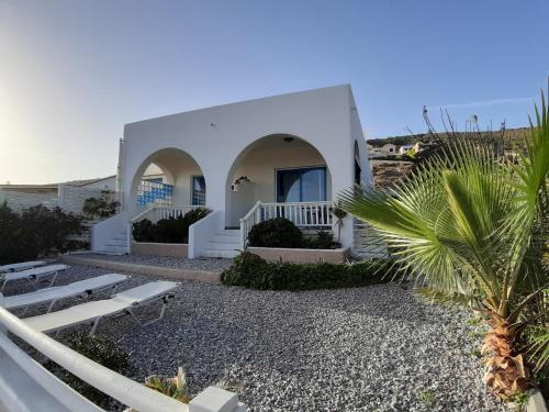 a white house with a palm tree in front of it at villa vagelis in Mourteri