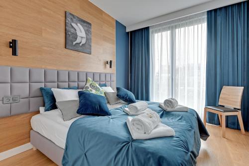 a bedroom with a large bed with towels on it at The Maritime Suite - Luxury Botanica in Gdańsk
