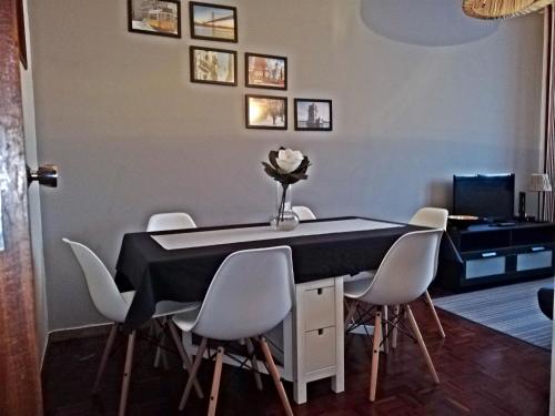 里斯本的住宿－羅馬旅遊公寓，餐桌、白色椅子和书桌