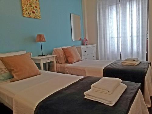 ein Schlafzimmer mit 2 Betten und Handtüchern darauf in der Unterkunft TripGeo Apartment Roma in Lissabon