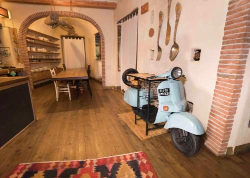 een blauwe scooter geparkeerd in een kamer met een tafel bij Palazzu Stidda Catania in Catania