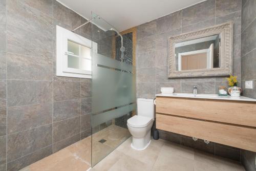 a bathroom with a toilet and a sink and a mirror at Villa Herdain in Alcudia