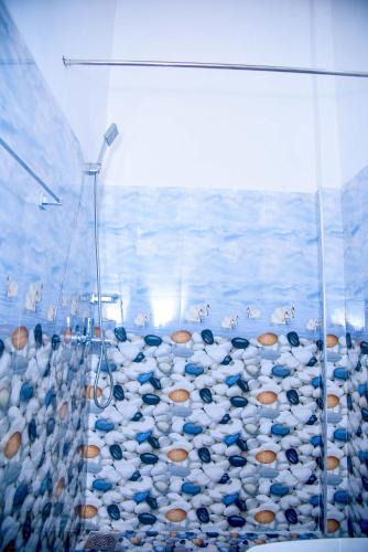a bathroom with a shower filled with blue and white toilets at City Beach Apartment in Bentota