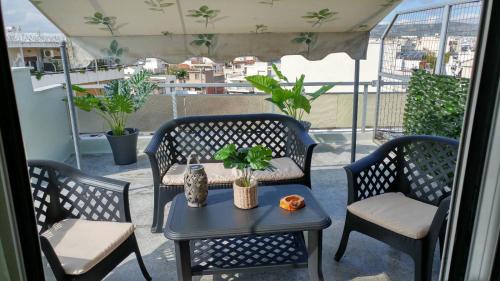 a patio with two chairs and a table on a balcony at Tropical Loft with View in Volos
