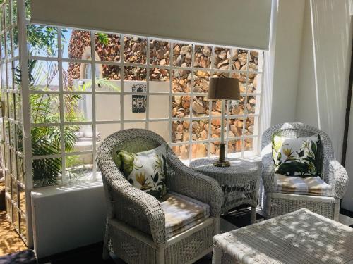 two chairs and a table in a room with a window at Ashbourne Country Escape Hazyview in Hazyview