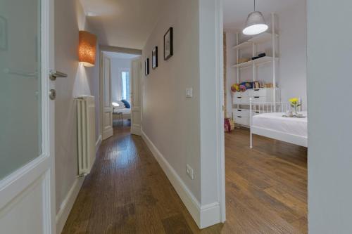 a hallway with white walls and wood floors in a room at - Guelfa Apartment - in Florence