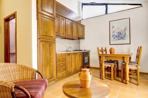 a living room with a table and a kitchen at Hotel Residence Villa Rioddi in Volterra