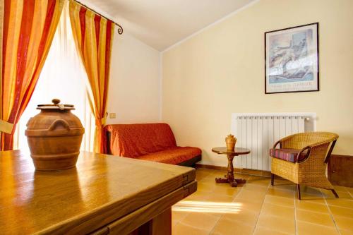 a living room with a table and a chair at Hotel Residence Villa Rioddi in Volterra