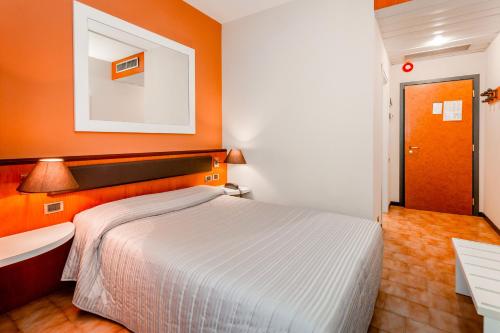 a bedroom with a bed and a sink and orange walls at RHI Porta Bologna in Pieve di Cento