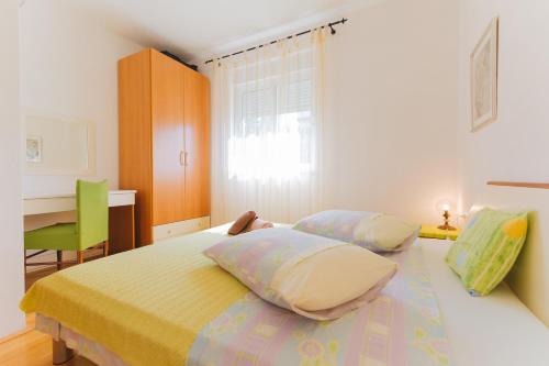 a bedroom with a bed with two pillows and a desk at Apartmani Villa Marija in Omiš
