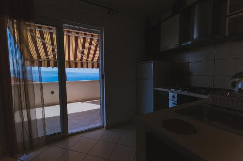 a kitchen with a sliding glass door to a balcony at Apartmani Villa Marija in Omiš