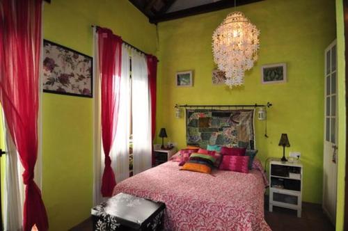 a bedroom with a bed and a chandelier at `PRECIOSA CASA ANDALUZA CON VISTAS in San Roque