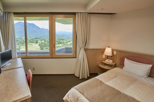a hotel room with a bed and a window at Myogi Green Hotel in Tomioka