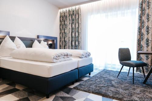Un dormitorio con una cama y una silla y una ventana. en Winzerhof Dürauer, en Furth