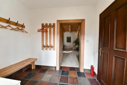 a hallway with a wooden door and a tiled floor at Leśny Domek koło Karpacza - Apartamentuj in Karpacz