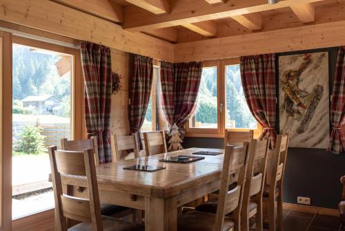 une salle à manger avec une table et des chaises en bois dans l'établissement Chalet Talini, aux Gets