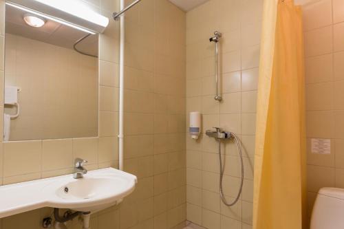 a bathroom with a sink and a shower at Viiking Spa Hotel in Pärnu