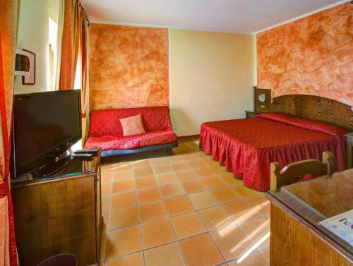 a room with two beds and a flat screen tv at Hotel Residence Villa Rioddi in Volterra