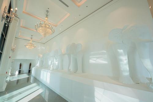 The Empress Premier Chiang Mai - SHA Extra Plus في شيانغ ماي: علبة عرض بيضاء في غرفة بيضاء وبها تماثيل