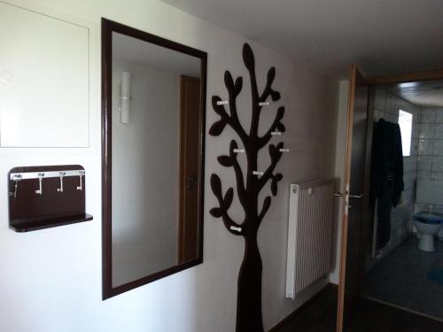 a mirror in a bathroom with a tree decal on the wall at Ferienwohnung Landblick in Bucha